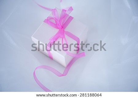 Gift box with ribbon on cloth background