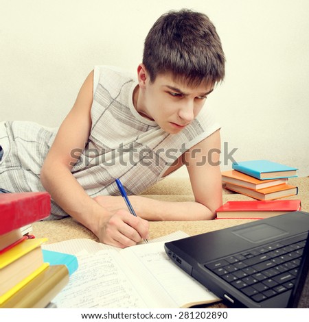 Toned Photo of Serious Teenager doing Homework on the Sofa at the Home