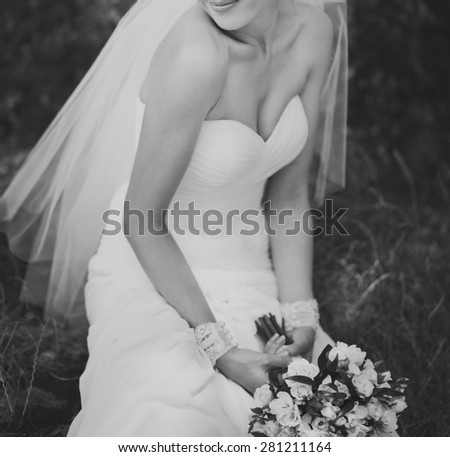 Black and white picture of a bride with bouquet outside. 