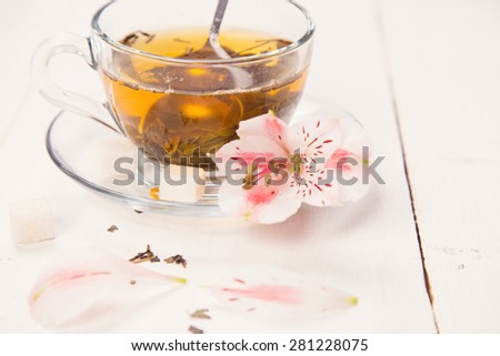 green fresh tea with a spoon, sugar and flower