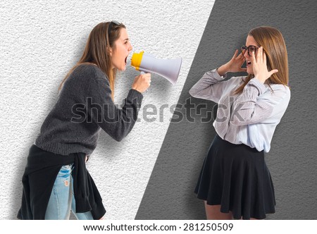 Girl shouting at her sister by megaphone  
