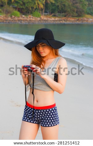 Cheerful woman talking pictures with digital camera