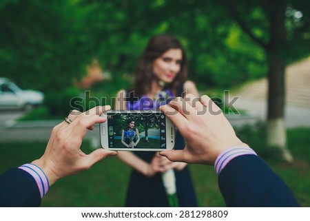a man is taking pictures of a beautiful girl on his phone
