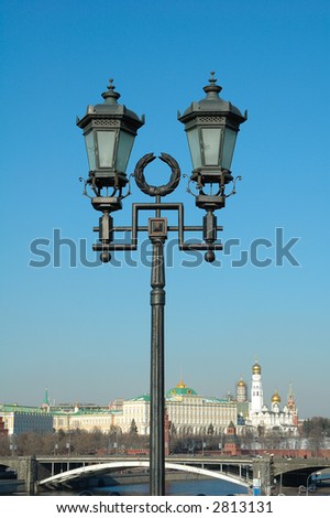 ornate street lamp with a view of old city on the background