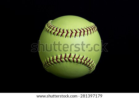 Yellow fastpitch softball on black background