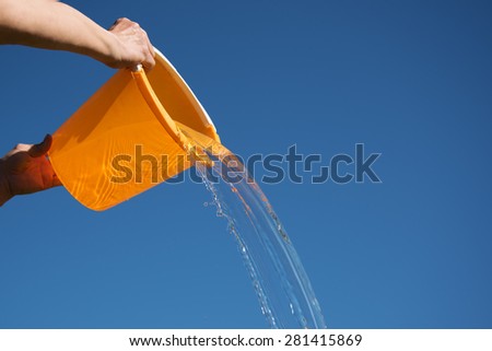 Pouring water against blue sky. Royalty-Free Stock Photo #281415869
