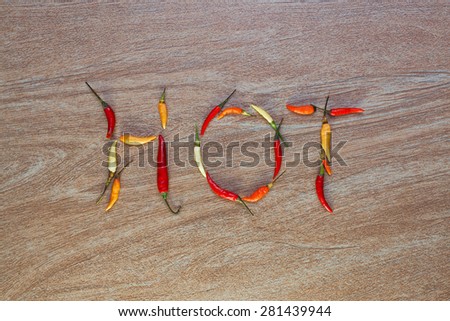 Layout of multicolor chili peppers forming a word on a wooden background