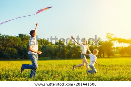 happy family in summer nature. Dad, mom and son child flying a kite Royalty-Free Stock Photo #281441588