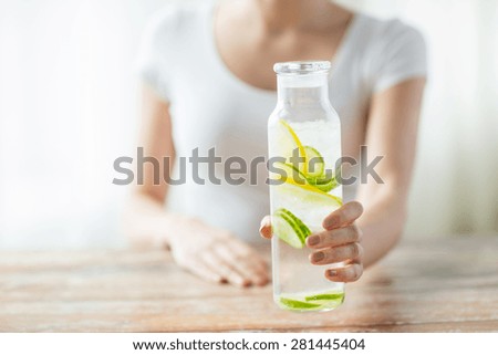 healthy eating, drinks, diet, detox and people concept - close up of woman with fruit infused water in glass bottle Royalty-Free Stock Photo #281445404