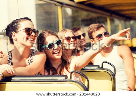 friendship, travel, vacation, summer and people concept - group of smiling friends traveling by tour bus Royalty-Free Stock Photo #281448020