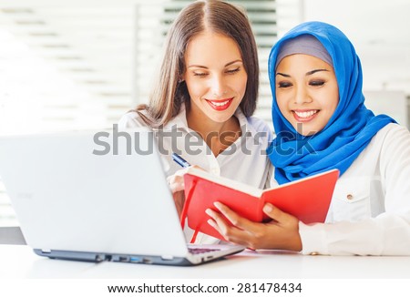 Native speaker teaching a muslim asian girl in a light classroom in college