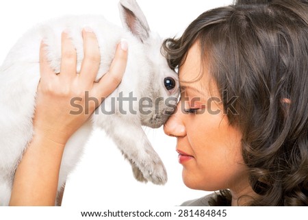 Young woman kissing a rabbit in her hands isolated on white background