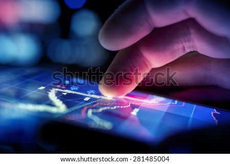 A businessman using a mobile device to check market data. Royalty-Free Stock Photo #281485004