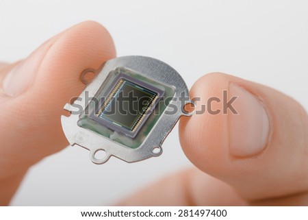 Small digital camera sensor plate in fingers Royalty-Free Stock Photo #281497400