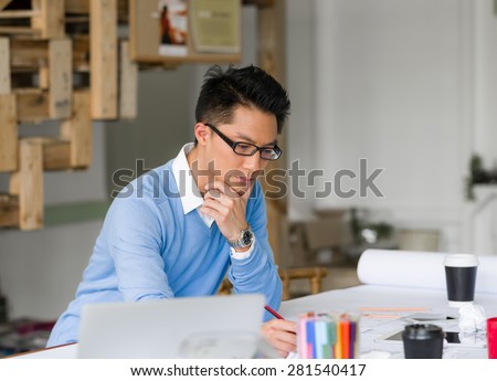Young chineese engineer working in office