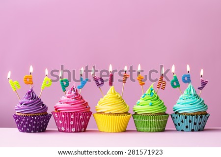 Cupcakes with candles spelling the words "happy birthday"
