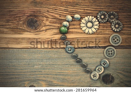vintage buttons heart on old textured boards of ancient tailor table with copy space. instagram image filter retro style