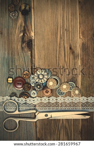 vintage buttons, lace, and a dressmaker scissors on a textured surface of old boards. instagram image filter retro style