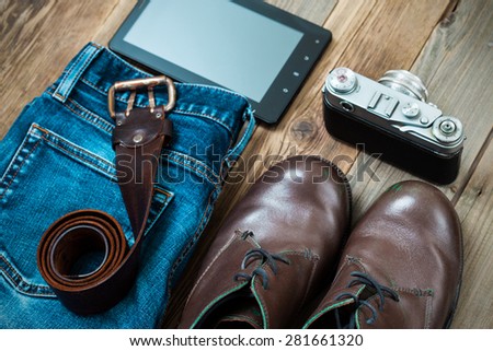 traveler set with a digitizer, rangefinder camera,  leather belt, blue jeans and brown boots
