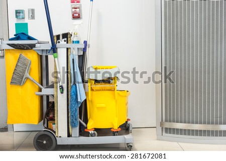 Yellow mop bucket and set of cleaning equipment in the airport