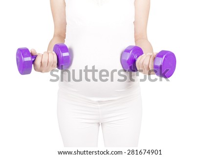 Pregnant female do exercise in sports hall, side view, body part, lifting dumbbells, active and sportive pregnancy, healthy motherhood concept