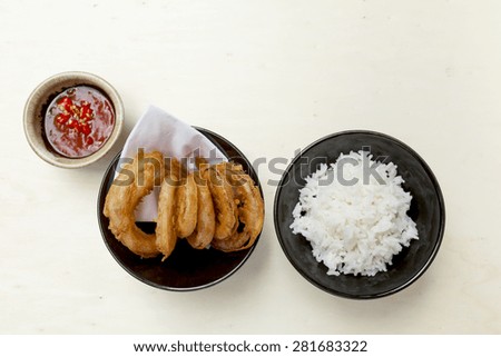 Deep fried onion with rice and red chili sauce with space on wood table