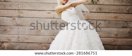 Wedding picture of happy bride against wooden background. 