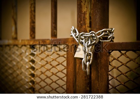 Rusty metal gate closed with padlock - concept image