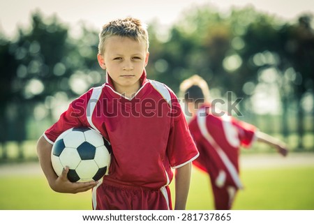 Young boy with soccer ball posing for picture