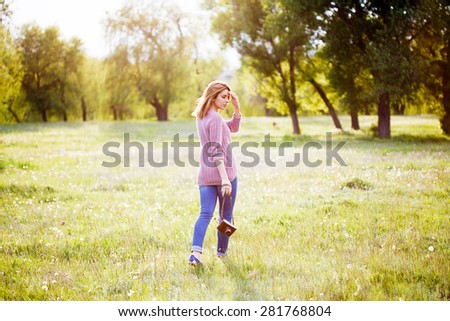 A beautiful girl with camera on nature.