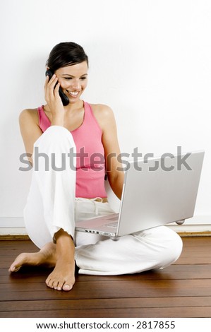 A pretty young woman sitting on wooden floor with laptop and mobile phone Royalty-Free Stock Photo #2817855