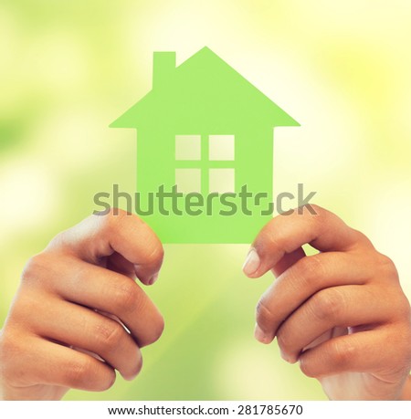 business, eco and real estate concept - closeup picture of woman hands holding green house