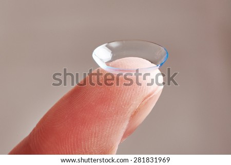 Medicine and vision - womans finger with contact lens