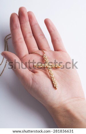 Female hand holding a cross