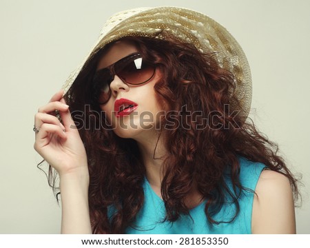 Beautiful young surprised woman wearing hat and sunglasses