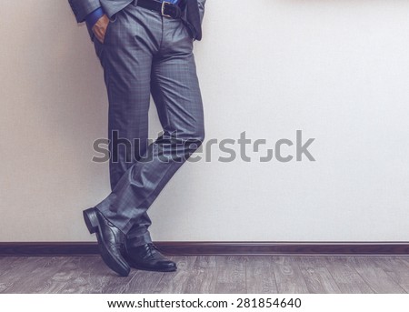 Young fashion businessman's legs in classic suit and shoes on wooden floor Royalty-Free Stock Photo #281854640