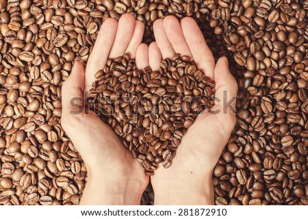 Coffee beans in the hands of heart shaped