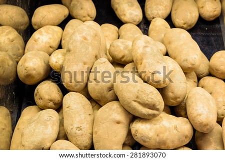 A heap of raw baking potatoes tubers in a supermarket at Colfax, Whitman County, Washington, USA. Panoramic style.