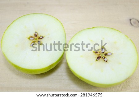 Apple sliced in thin pieces on a wooden table