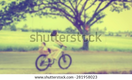 blurred mother and son riding bicycle, vintage filter