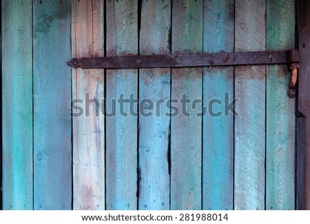 Weathered blue wall made of wood with a hinge
