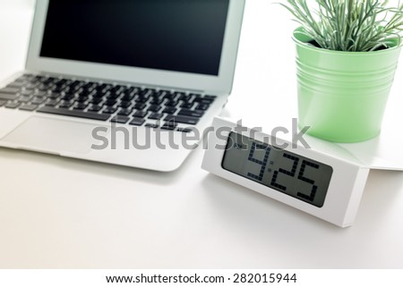 Laptop and flower pot with clock