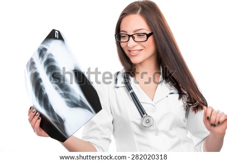 Young female doctor with a stethoscope looking at the x-ray picture of lungs on white 