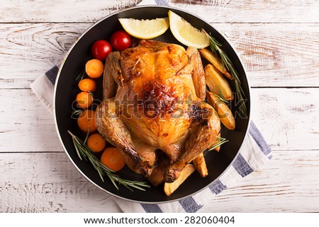Roasted chicken and vegetables on the wooden table Royalty-Free Stock Photo #282060404