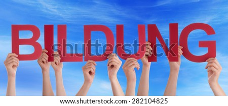 Many Caucasian People And Hands Holding Red Straight Letters Or Characters Building The German Word Bildung Which Means Education On Blue Sky