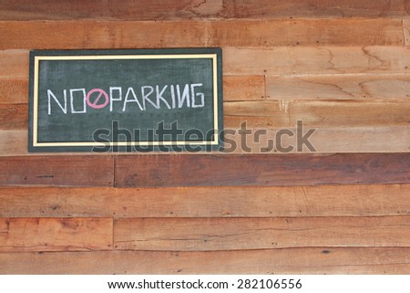 No parking sign out front yard on wood wall.