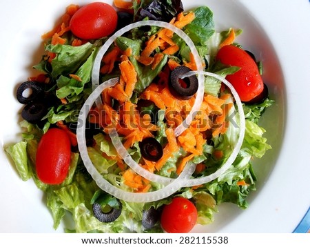 Royalty Free Photograph - Appetizing Organic Mixed Greens Salad with Red Ripe Grape Tomatoes and Onion Rings in a White Bowl - Isolated Close Up Photograph