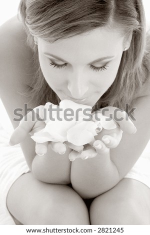 monochrome picture of woman in spa smelling white rose petals