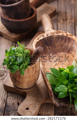 A bunch of Basil in an old bowl. Wooden old kitchenware.selective focus