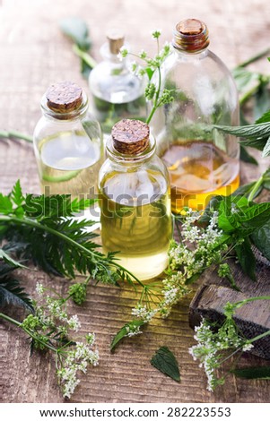 Organic essential aroma oil with  herbs on aged wooden background. Homeopathy. Selective focus.  